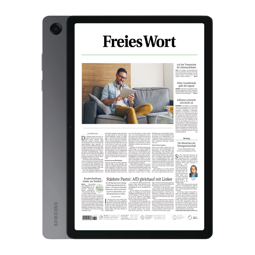 Tablet in a protective case displaying the Freies Wort front page, with a man on a sofa reading on a tablet in the layout window